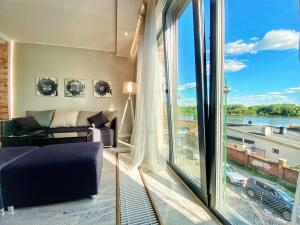 a living room with a couch and a large window at BP III Premium in Toruń
