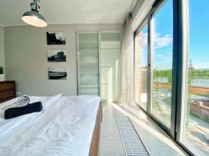 a bedroom with a bed and a large window at BP III Premium in Toruń