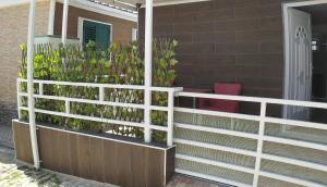 a fence with plants on the side of a house at Residencial T2 no Parque Verde in Quinta do Conde