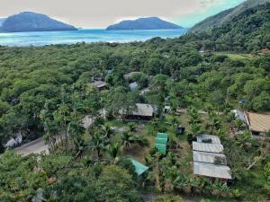 an aerial view of a resort with palm trees and the ocean at Piratas Cabanas Camping Bar in Parati-Mirim