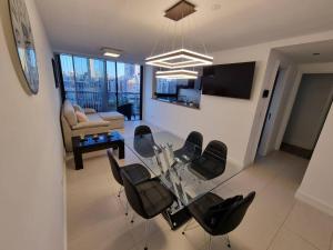 uma sala de estar com uma mesa de vidro e cadeiras em Departamento 2 amb frente a Casino em Mar del Plata