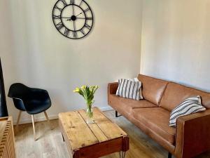 a living room with a couch and a clock on the wall at Les Rives du Château in Châteauroux