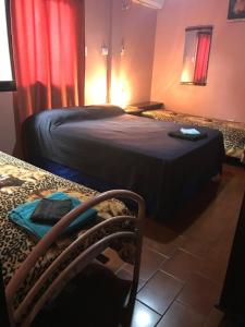Habitación con 2 camas y una silla. en Yate I en Puerto Iguazú