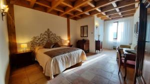 een slaapkamer met een bed, een tafel en een bureau bij Palazzo Laureano - Dimora Storica in Tricarico