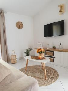 a white living room with a table and a tv at Apartment Macic Dub II in Kotor
