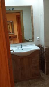 a bathroom with a white sink and a mirror at Vivienda Sierra de San Marcos in Golmayo