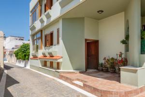 a facade of a building with a door and a sidewalk at Green Sunshine in Theologos