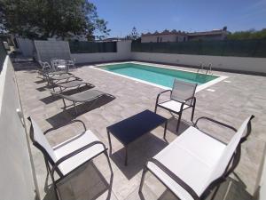 - un groupe de chaises et une piscine dans l'établissement Casa con piscina Profumo Sea & Sun 2, à Triscina