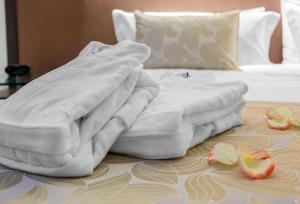 una pila di asciugamani appoggiata sopra un letto di Sonesta Valledupar a Valledupar