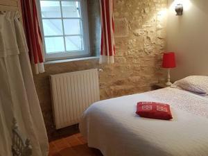 ein Schlafzimmer mit einem Bett mit einer roten Tasche darauf in der Unterkunft Gîte Arçonnay, 6 pièces, 14 personnes - FR-1-410-300 in Arçonnay