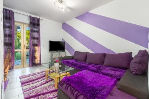 a purple living room with a couch and a tv at Apartment Belma Poreč in Radmani