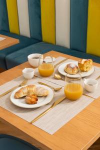 une table avec des assiettes de nourriture et des verres de jus d'orange dans l'établissement ramo d'oro, à Naples