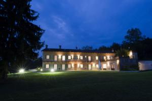 een groot huis met lichten op een veld 's nachts bij Sangrato 1883 in Monteu Roero