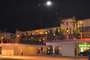 ein Gebäude mit Balkon und nachts ein Parkplatz in der Unterkunft Casa Del Sol Motel in Wildwood