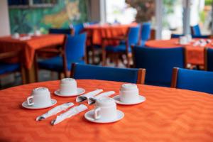 a table with plates and cups and napkins on it at Hotel Ave del Paraíso in San José