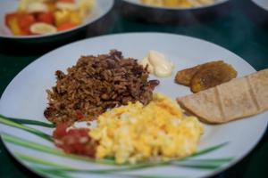 a white plate of food with eggs and other foods at Hotel Ave del Paraíso in San José +38 photos