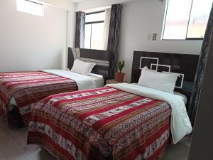 库斯科Hostal Killaly Inn Cusco的房间里有两张并排的床