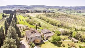 z góry widok na dom na wzgórzu z drzewami w obiekcie Appartamenti Villa La Fonte w mieście San Gimignano