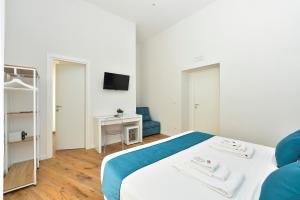 - une chambre avec un lit blanc et un canapé bleu dans l'établissement ramo d'oro, à Naples