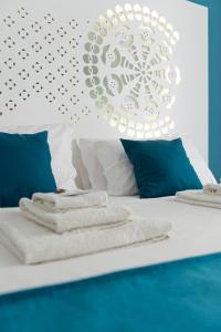 1 cama con sábanas blancas y almohadas azules en ramo d'oro en Nápoles