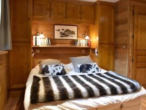 a bedroom with a large bed with wooden walls at Appartement cosy avec cheminée, terrasse et parking, proche pistes et commerces - Méribel - FR-1-180-552 in Méribel
