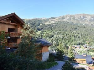 a building with a view of a mountain at Appartement cosy avec cheminée, terrasse et parking, proche pistes et commerces - Méribel - FR-1-180-552 in Méribel