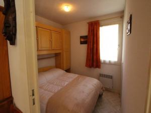 um pequeno quarto com uma cama e uma janela em Appartement Bagnères-de-Luchon, 3 pièces, 4 personnes - FR-1-313-178 em Luchon
