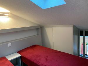 a bedroom with a red bed and a skylight at Appartement Loupian, 2 pièces, 4 personnes - FR-1-604-9 in Loupian