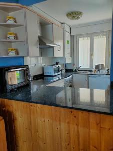 a kitchen with white cabinets and a counter top at APARTAMENTO PLAYA DE USIL in Mogro