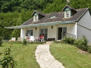 una casa blanca con gente sentada en el porche en Gîte Saint-Pierre-sur-Orthe, 4 pièces, 7 personnes - FR-1-600-185, en Saint-Pierre-sur-Orthe