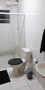 a white bathroom with a toilet and a sink at Apto Aeroporto Macae in Macaé