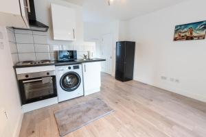 a kitchen with a washing machine and a refrigerator at Flat 03 Studio flat near Aylesbury Station Free Parking in Buckinghamshire