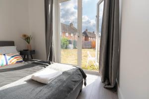 1 dormitorio con cama y ventana grande en Flat 03 Studio flat near Aylesbury Station Free Parking, en Buckinghamshire