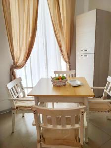 una cocina con mesa y sillas con un bol de fruta. en Zefnea House, en Catania