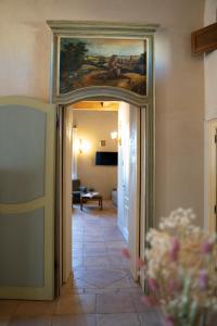 a hallway with a painting on the wall and a room at Palazzo Laureano - Dimora Storica in Tricarico +9 photos