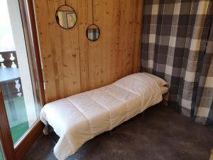 ein kleines Bett in einem Zimmer mit Holzvertäfelung in der Unterkunft Appartement cosy à Châtel - 5 pers, WIFI - FR-1-198-207 in Châtel