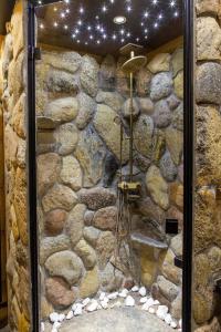 a stone bathroom with a shower with a stone wall at SASKI ZAKĄTEK, WAKACJE W BAJKOWYM DOMKU!!! MAZURY, SAUNA, JEZiORO, POMOST, in Sasek Mały
