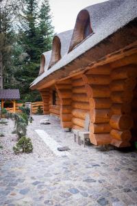 a log cabin with two chairs in front of it at SASKI ZAKĄTEK, WAKACJE W BAJKOWYM DOMKU!!! MAZURY, SAUNA, JEZiORO, POMOST, in Sasek Mały