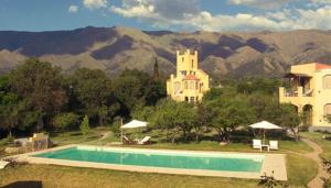 una piscina frente a una casa con montañas en Las Nubes Apart en Merlo