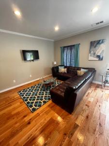 a living room with a leather couch and a television at Atlanta Unit 2 Room 2 - Peaceful Weekend Getaway Private Bedroom & Bathroom in Atlanta