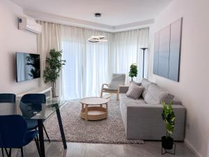 a living room with a couch and a glass table at Daimond Complex Sea View Apartment in Paphos City