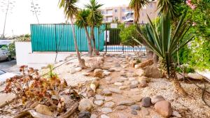a garden with palm trees and rocks at Daimond Complex Sea View Apartment in Paphos
