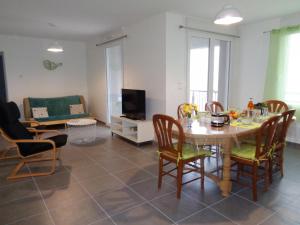 - un salon avec une table, des chaises et une télévision dans l'établissement Appartement Saint-Genest-Malifaux, 2 pièces, 2 personnes - FR-1-496-228, à Saint-Genest-Malifaux