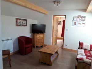 uma sala de estar com uma televisão, um sofá e uma mesa em Appartement Albiez-Montrond, 4 pièces, 8 personnes - FR-1-618-3 em Albiez-Montrond