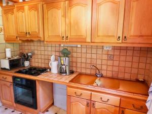 a kitchen with wooden cabinets and a sink at Chalet Valfréjus, 5 pièces, 6 personnes - FR-1-468-39 in Valfréjus