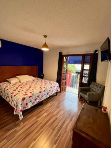 Schlafzimmer mit einem Bett und einer Glasschiebetür in der Unterkunft Hotel Casa Frida in Cuernavaca