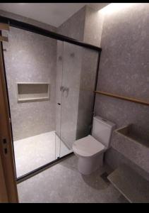 a bathroom with a toilet and a glass shower at Salinas Premium Resort 409 in Salinópolis