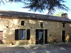 Un antiguo edificio de piedra con puertas y ventanas negras. en Charmante maison à la ferme avec jardin, terrasse, BBQ, proche sites touristiques, animaux bienvenus - FR-1-616-125, en Saint-Pardoux-et-Vielvic