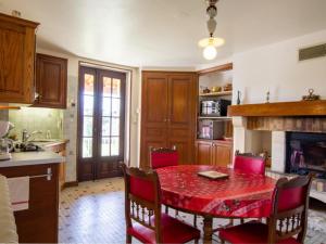 una cucina con tavolo rosso e sedie in camera di Maison Périgourdine avec Jardin, Vélos, Terrasse et Proche Nature - FR-1-616-133 a Thiviers