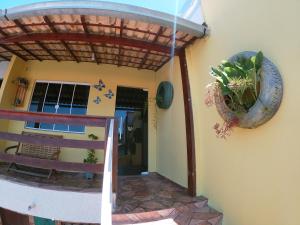 un porche con pérgola y una planta en Vila da Drika en Rio das Ostras